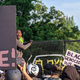 A protester scales a fence at the White House—to urge the rest of the crowd to refrain from shaking it.